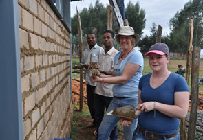 Students and locals build hen houses.