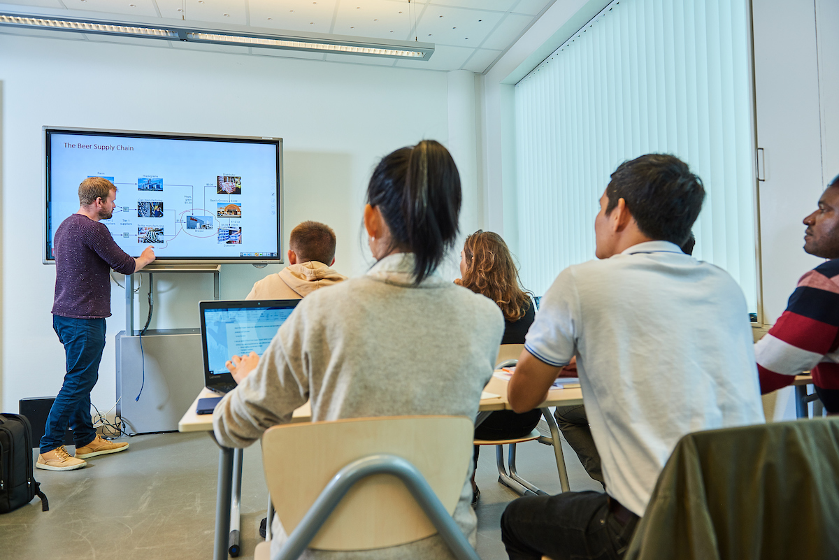 A teacher gives a presentation in a classroom.